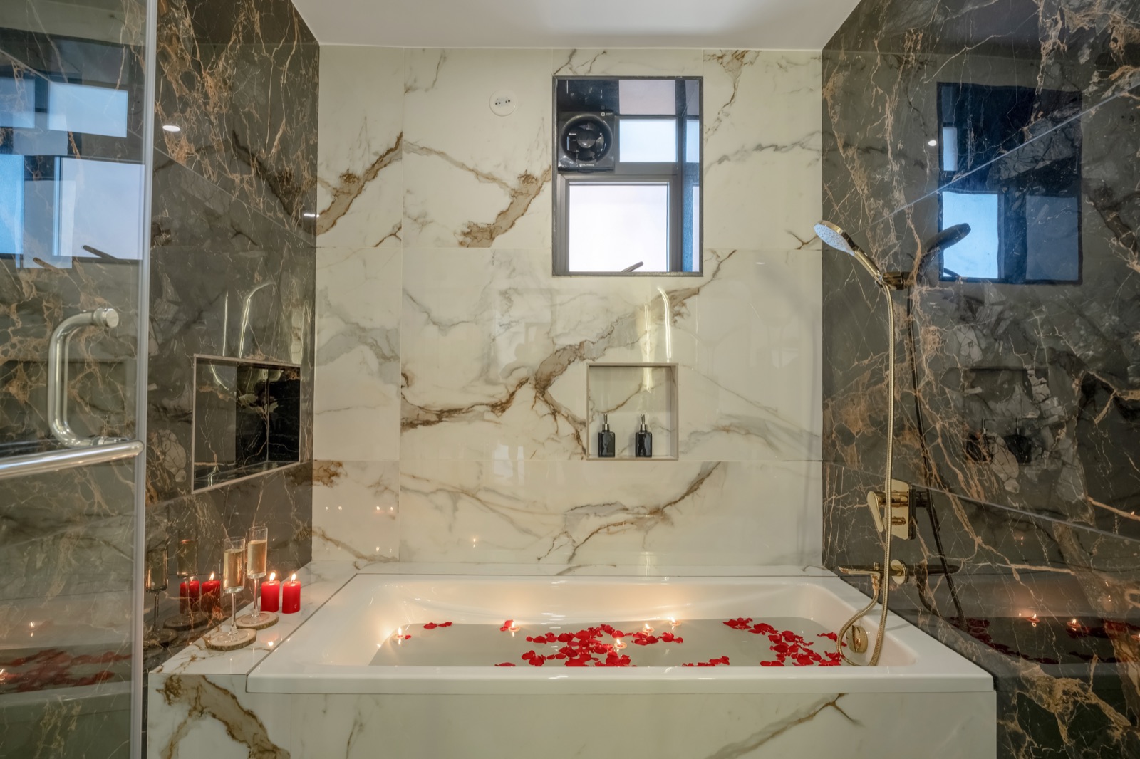 Marble bathroom with freestanding tub, candles and brass fittings
