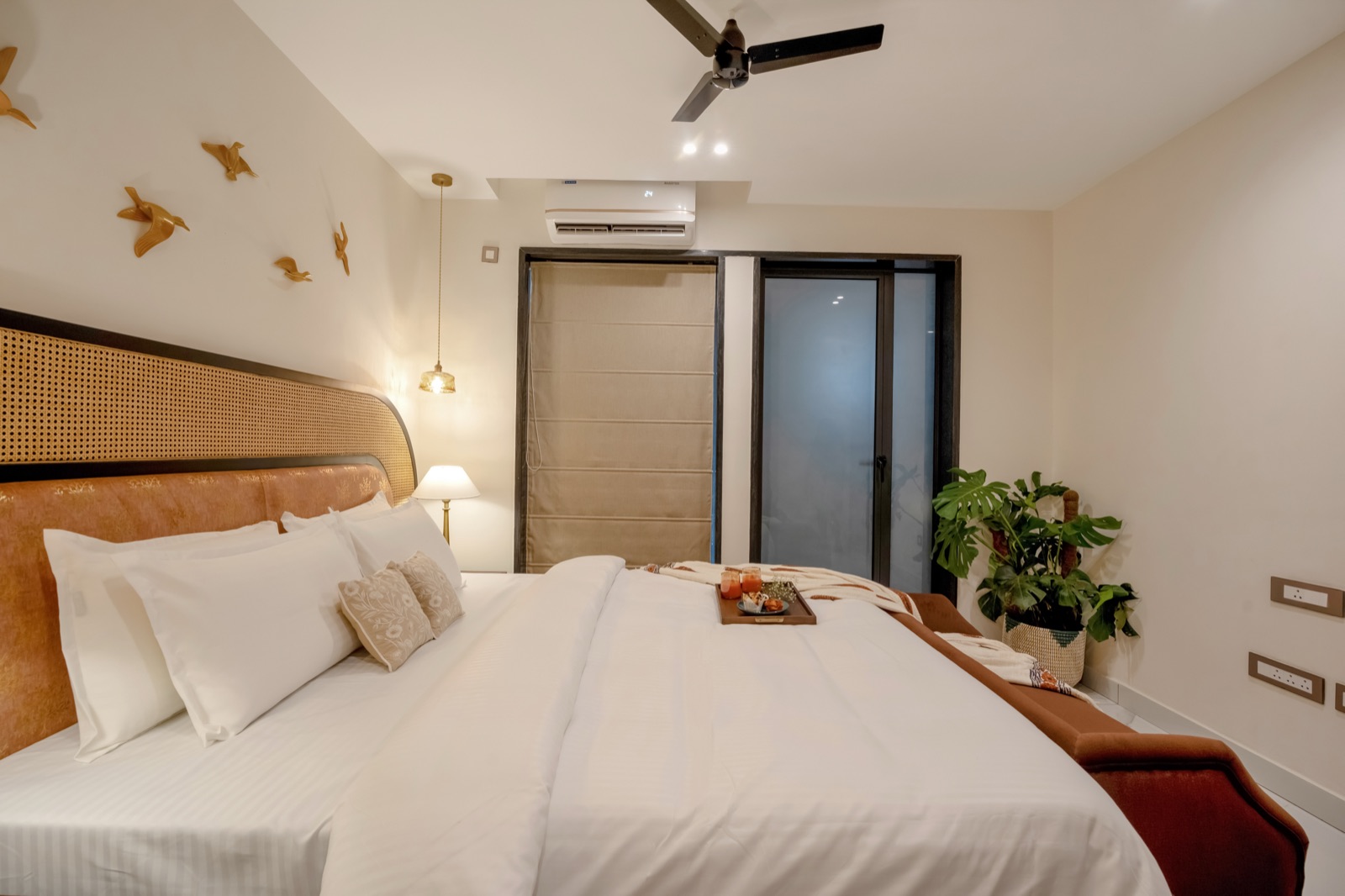 Guest bedroom with cane headboard and brass goldfish wall detail
