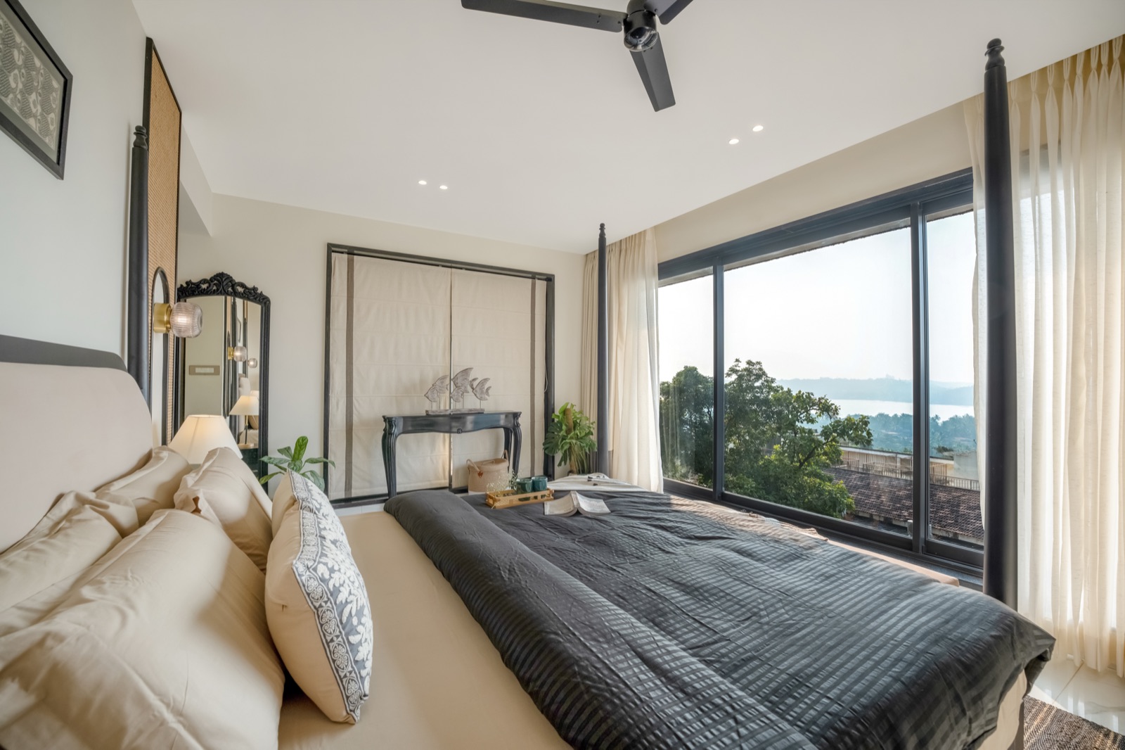 Four-poster bedroom looking out to greenery and the water beyond